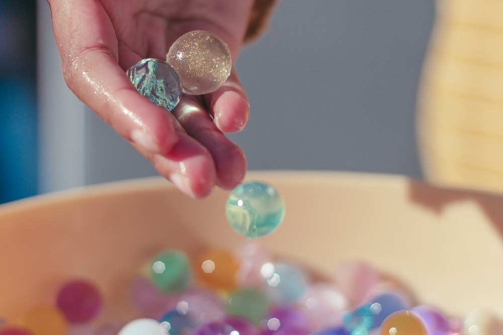 hand in a bowl of marbles