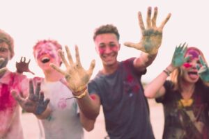 teens covered in paint with hands outstretched towards camera